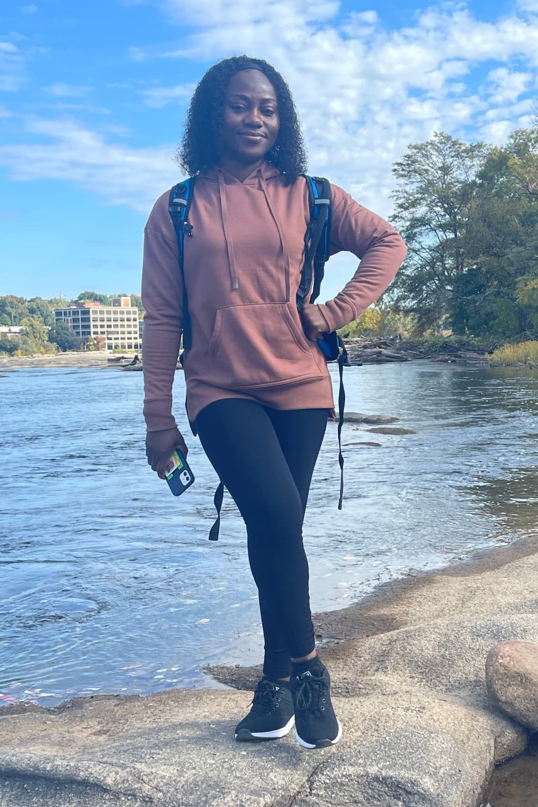 Student posing on rocks in front of the James River