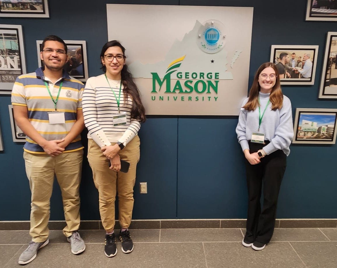 students stand in front of George Mason University Sign